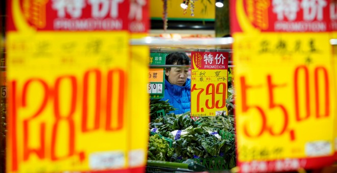 Una mujer selecciona verduras en un supermercado en Pekín. REUTERS / Jason Lee