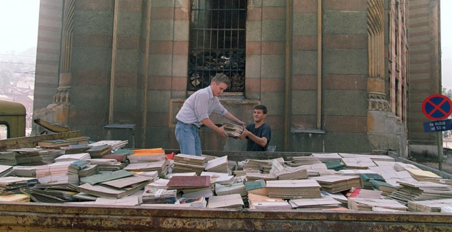 Residentes de Sarajevo intentan salvar algunos libros del incendio provocado por un bombardeo serbio en la Biblioteca Nacional de Bosnia, el 29 de agosto de 1992.- AFP