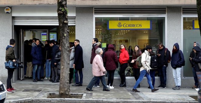 Decenas de personas hacen cola este jueves en una oficina de Correos de la capital. - EFE