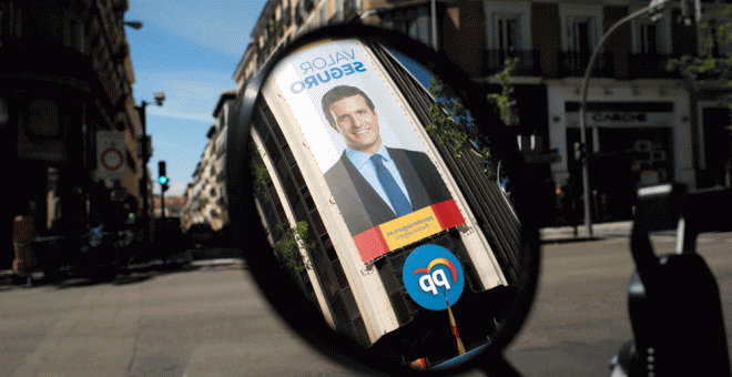 29/04/2019.- Un póster de Pablo Casado reflejado en el espejo de una moto. REUTERS/Jon Nazca