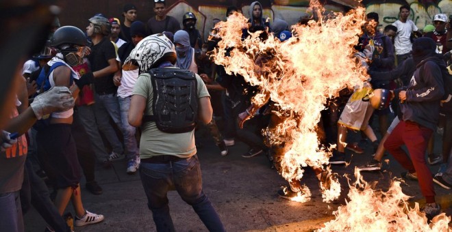 El joven Orlando Figuera envuelto en llamas.- AFP
