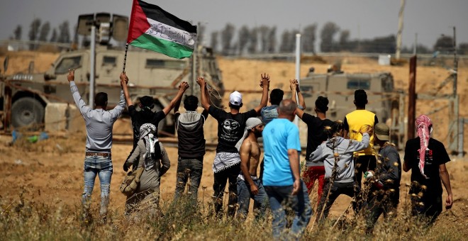 Los manifestantes palestinos hacen gestos frente a las fuerzas israelíes durante la protesta. Reuters