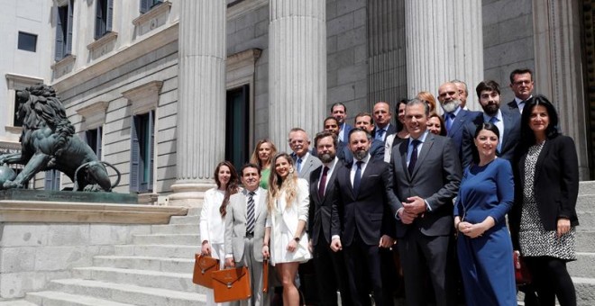 El líder de Vox Santiago Abascal (c), posa en la entrada del Congreso junto a sus diputados electos tras presentar este viernes sus credenciales en la Cámara Baja.