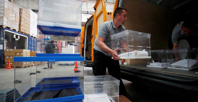 Los operarios trasladan las urnas que se van a emplear en la jornada electoral del 26-M. REUTERS/Albert Gea