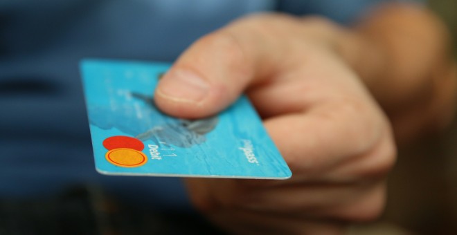 Un hombre sujeta una tarjeta de crédito, que contiene el mismo número de plásticos que puede consumir el ser humano a la semana./ PixaBay