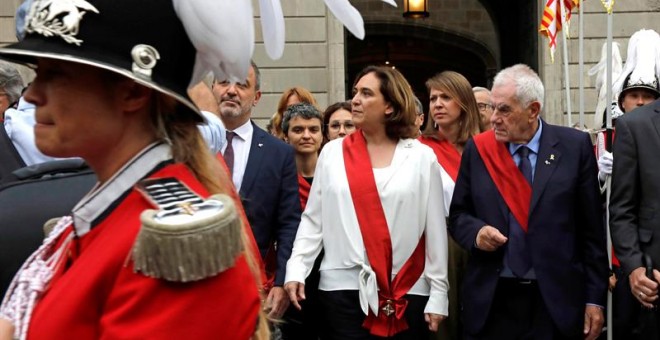 La alcaldesa Ada Colau, junto a Jaume Collboni y Ernest Maragall, cruzan la Plaza de Sant Jaume hacia el Palau de la Generalitat entre los gritos y abucheos del público asistente, hoy sábado en Barcelona. EFE/Susanna Sáez