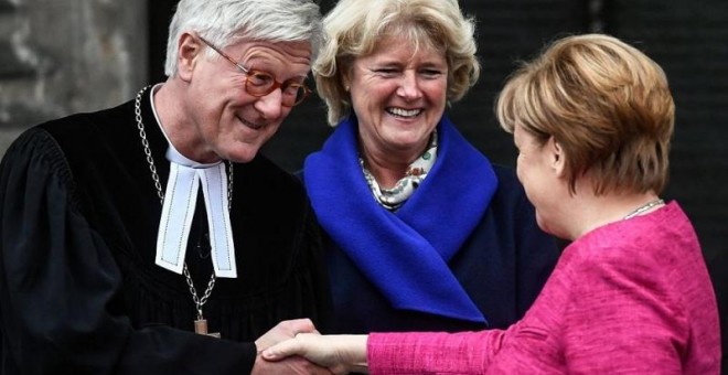 La canciller alemana, Angela Merkel (d), saluda al presidente del Consejo de la Iglesia Evangélica, Heinrich Bedford-Strohm (i). EFE