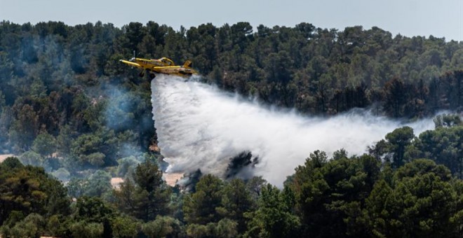 Un hidroavió treballa en les tasques d'extinció de l'incendi de la Ribera d'Ebre. EFE / Mario Gascón.