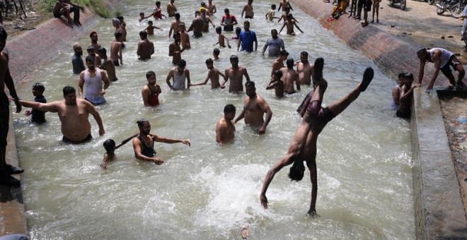 Varias personas se bañan en un canal para combatir el calor en Amritsar (India). /EFE