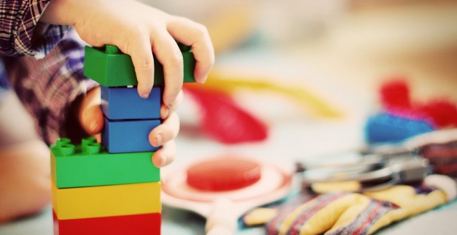 Niño jugando con una torre de construcción. / Pixabay