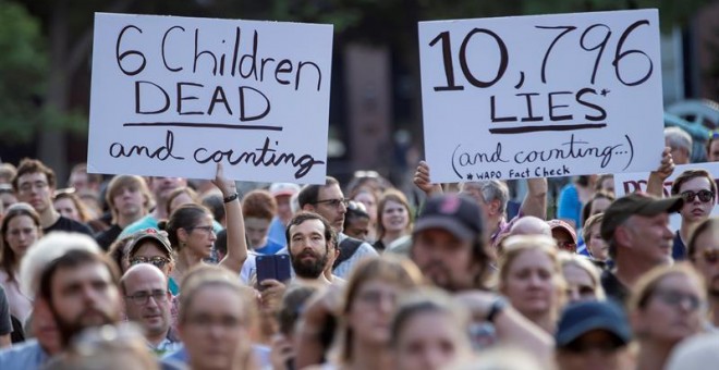 Manifestantes sostienen carteles en los que se leen '6 niños muertos y contando' (i) y '10.796 mentiras y contando' (d) -en referencia al presidente Trump- durante una manifestación este viernes, fuera de la Casa Blanca, en Washington (EE.UU.). La protest