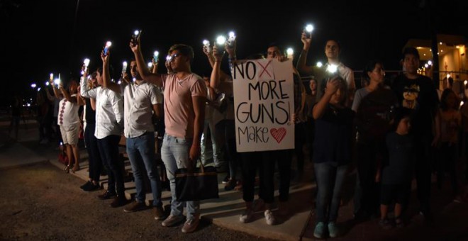 Decenas de personas oran este sábado, en la línea fronteriza de Ciudad Juárez (México), tras el tiroteo en un centro comercial de El Paso. EFE/ Rey Jauregui