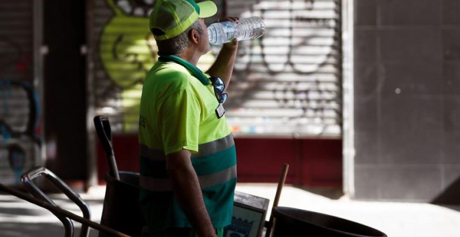 Un empleado de limpieza del ayuntamiento de Madrid bebe agua, una de las medidas recomendadas para evitar los golpes de calor y la deshidratración en sta calurosa mañana de sábado de agosto. EFE/MARISCAL