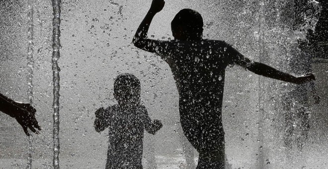 Varios jóvenes en Pamplona refrescándose en una de las fuentes de la capital navarra. EFE/Villar López.