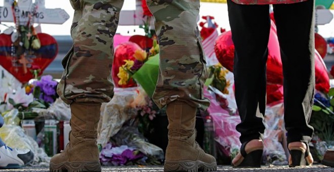 06/08/2019 - Un miembro del ejército se para frente a un memorial improvisado realizado después de un tiroteo masivo que ocurrió en un Walmart, en El Paso, Texas.