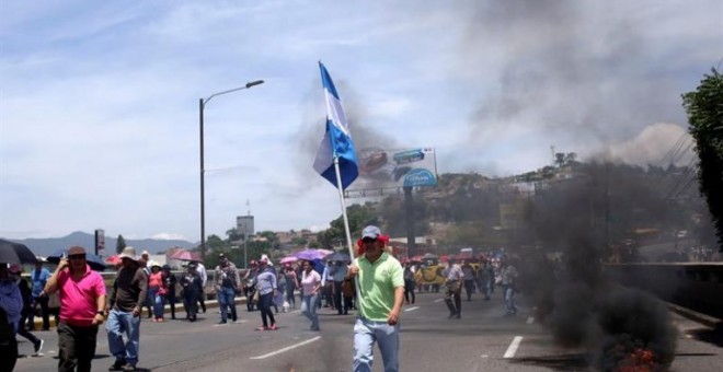 Manifestantes se enfrentan a la policía de Honduras durante una protesta exigiendo la salida del presidente, Juan Orlando Hernández, señalado por la Fiscalía de Nueva York en una presunta conspiración para usar dinero del narcotráfico con el fin de manten