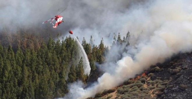 Un helicóptero en el incendio declarado este sábado en la zona de Artenara en el oeste de la isla de Gran Canaria | EFE