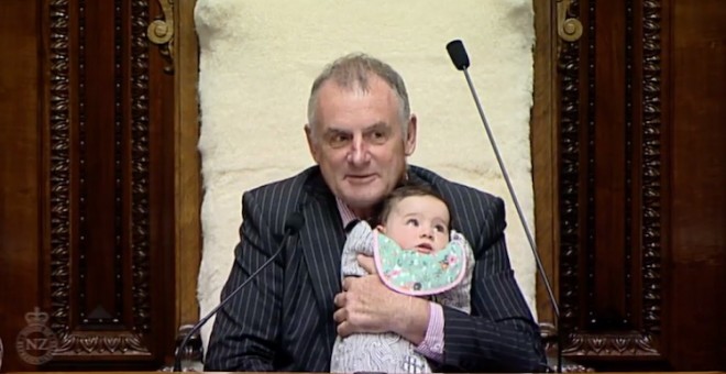 El presidente del Parlamento neozelandés, Trevor Mallard, sostiene a la hija de una diputada mientras preside el pleno en 2017. Captura de pantalla.