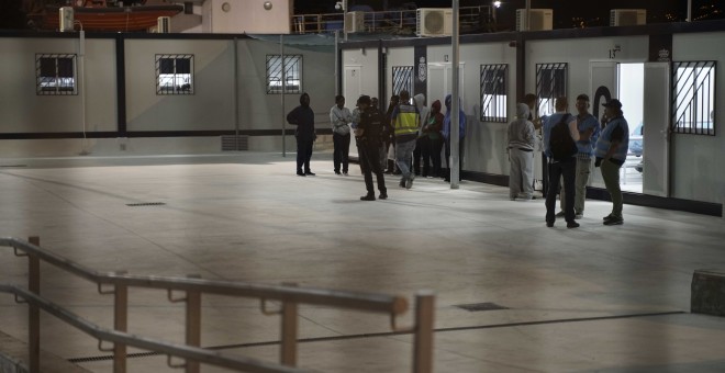 Migrantes y personas de la Policía Nacional y FRONTEX, en el interior del CATE de Málaga.- ENTREFRONTERAS
