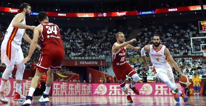 El base de la selección española Ricky Rubio (d) conduce un balón con base polaco ALukasz Koszarek. /EFE