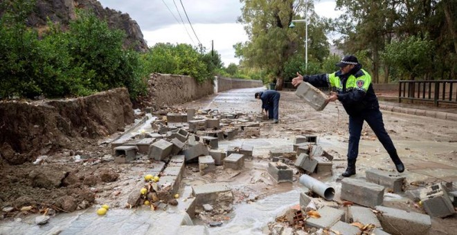 Policías locales de Blanca, Murcia, retiran los bloques de un muro derribado por las fuertes lluvias. - EFE