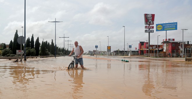 Un hombre camina por una calle inundada tras de fuertes lluvias por la gota fría en San Javier, Murcia.- REUTERS / SERGIO PÉREZ