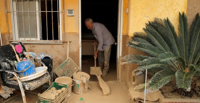 Un hombre elimina el lodo acumulado por las lluvias torrenciales en su casa de Orihuela, Alicante.- JON NAZCA / REUTERS