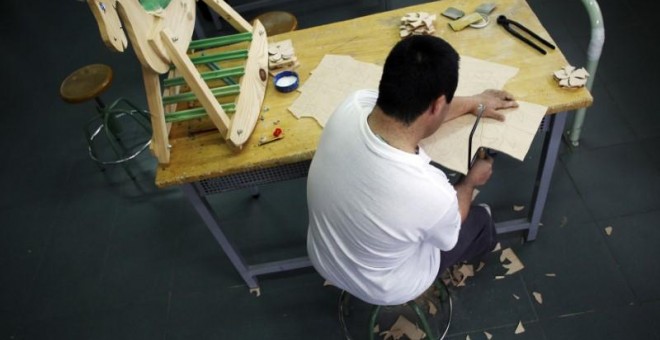 Un hombre con discapacidad psíquica trabaja en un taller de madera de un centro ocupacional para adultos con discapacidad psíquica dirigido por la Fundación Fuente Agria en Puertollano. REUTERS/Susana Vera