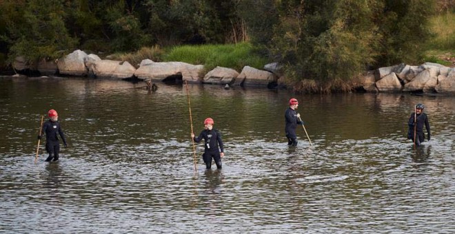 Agentes de los Mossos d'Escuadra y de los Bomberos buscan al bebé arrojado al río Besós. (EFE)