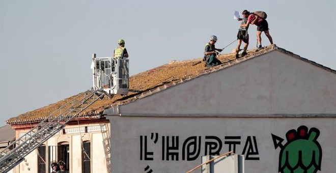 Els dos joves que es van lligar a la teulada de l'alqueria Forn Barraca a l'Alboraia, per impedir el seu esfondrament, s'abracen abans de ser detinguts per la Guàrdia Civil. EFE/Manuel Bruque