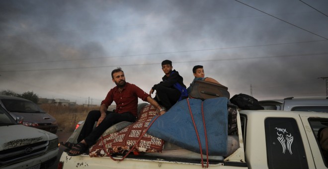Un grupo de sirios huyen de la ciudad de Ras al Ain.REUTERS/Rodi Said