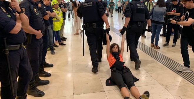 Dos mossos arrosseguen una activista dels CDR que formava part del bloqueig a l'Estació de Sants aquest diumenge al matí. Marià de Delàs