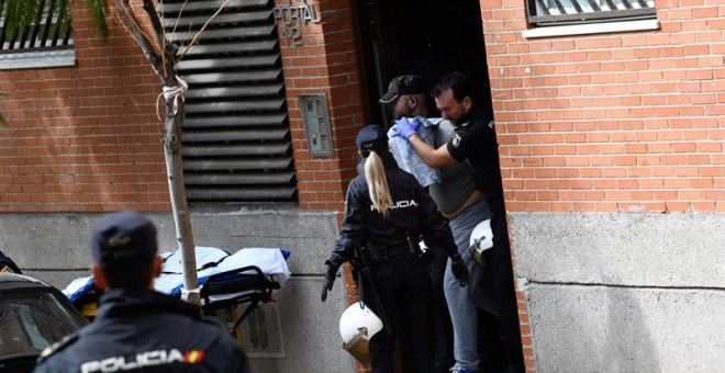 Agentes de la Policía Nacional reducen y sacan de la vivienda al hombre que se había atrincherado con una mujer este lunes en un piso en Leganés (Madrid). /EFE