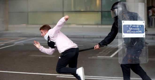 14/10/2019.- Miembros de los Mossos d'Esquadra cargan contra los centenares de personas que se agolpan ante el Aeropuerto del Prat. EFE/Toni Albir