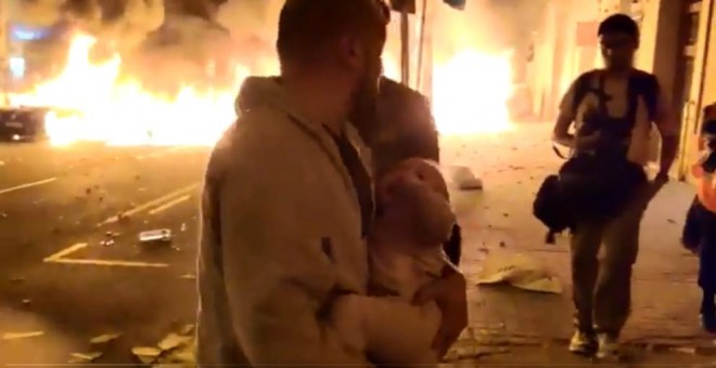 Imagen del hombre saliendo de su casa con su hija entre el fuego en la calle Roger de Flor de Barcelona. Cadena Ser