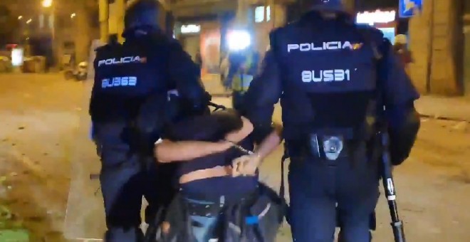 Momento en el que dos Mossos se llevan detenido al fotoperiodista Albert García.