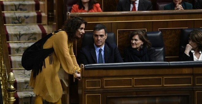 La ministra de Hacienda, María Jesús Montero, habla con el presidente y la vicepresidenta del Gobierno, Pedro Sánchez, y Carmen Calvo, tras una de sus intervenciones en el debate de totalidad de los Presupuestos del Estado para 2019. E.P./ Óscar del Pozo