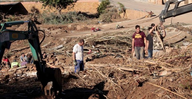 Varios vecinos realizan tareas de limpieza en la población de L'Espluga de Francolí (Tarragona) muy afectada por las riadas de esta semana,mientras los equipos de rescate ha intensificado este viernes la búsqueda de los 4 desaparecidos en las riadas. EFE/