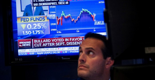 Un monitor de televisión informa de la nueva rebaja de tipos en EEUU, en el patio de negociación de la Bolsa de Nueva York, en Wall Street. REUTERS/Brendan McDermid