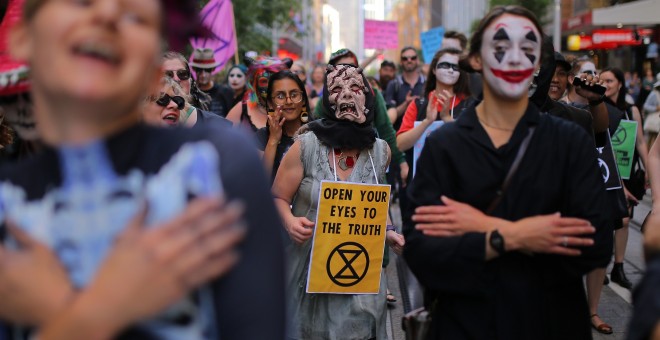 Manifestantes disfrazados participan en una protesta de Extinction Rebellion. EFE