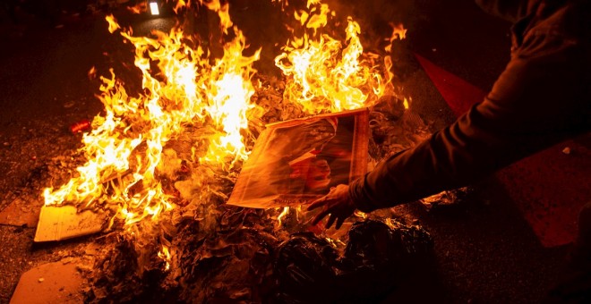 Varios manifestantes queman fotos del rey Felipe durante la protesta llevada a cabo en la avenida Diagonal de Barcelona, en protesta por la visita del monarca a la capital catalana. EFE/ Enric Fontcuberta