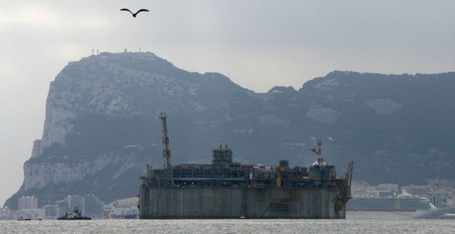 Los remolcadores tiran de una enorme terminal de gas natural licuado de hormigón, o GNL, construida por Acciona. REUTERS/Anton Meres