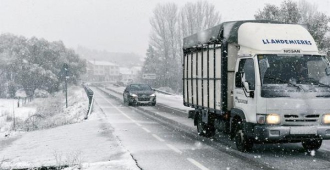 Varios vehículos circulan bajo la nieve en el municipio leonés de Riello este jueves. EFE