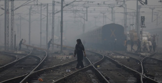 Una mujer cruza las vías del tren en una mañana brumosa en Nueva Delhi (India). REUTERS/Anushree Fadnavis