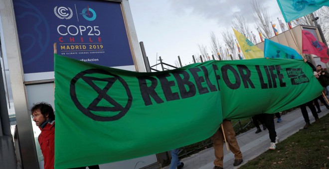 Activistas de Extinction Rebellion protestan en la entrada del recinto ferial de Ifema, en Madrid, al comienzo de la cumbre del clima. REUTERS/Juan Medina