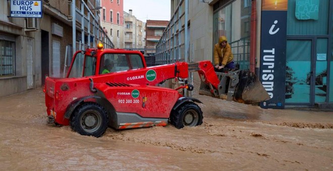 Un tractor traslada a un vecino del municipio de Los Alcázares, para cruzar una calle inundada hoy por las intensas lluvias caídas esta noche, de más de cien litros por metro cuadrado. EFE/Marcial Guillén
