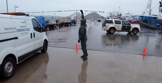 Agentes de la Guardia Civil controlan el acceso al puerto de Santoña, tras conocerse que un pesquero ha hallado a primera hora de esta mañana el cuerpo de una persona joven flotando. | EFE