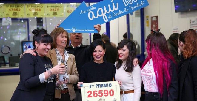 Un grupo de personas celebran en la administración madrileña de Doña Manolita que ha vendido el número 26.590, agraciado con el Gordo de Navidad. /EFE