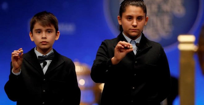 Los niños del colegio de San ildefonso Nerea pareja y Luis Alcides muestran las bolas con el número 41.710 que ha sido agraciado con el primero de los dos cuartos premios. /EFE