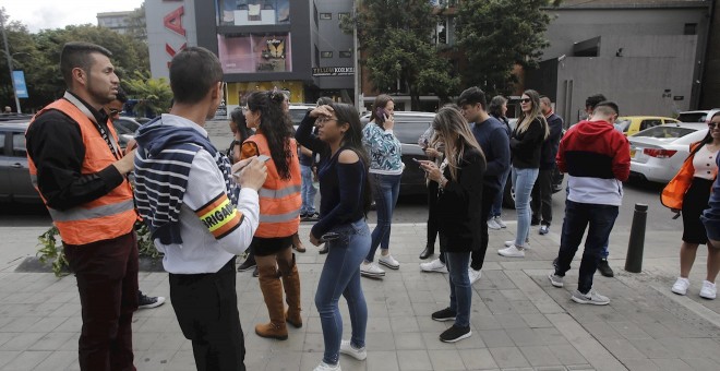 24/12/2019.- Varias personas esperan afuera de edificios este martes, 24 de diciembre de 2019 en el norte de Bogotá (Colombia). / EFE